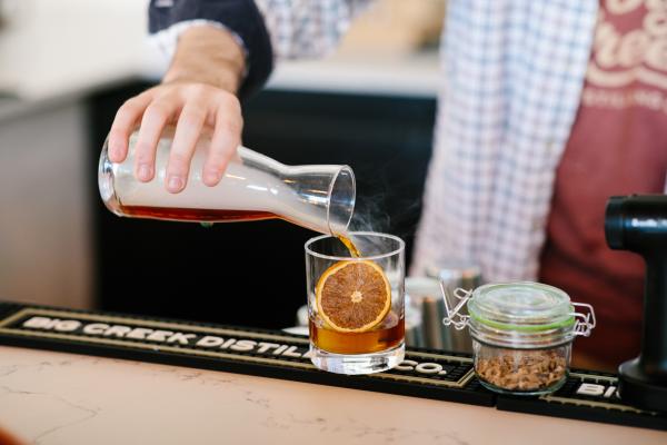 A smoked whiskey with a orange slice and bitters